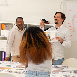 Julian vom Läbesruum arbeit mit zwei Personen an einem Workshop-Tisch.