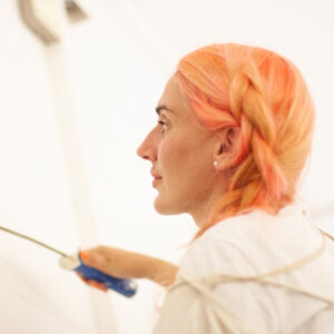 Stefania vom Läbesruum streicht eine Wand weiss.